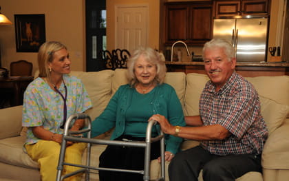 Caregiver sitting on couch with elderly couple