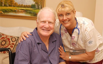 Elderly man in wheelchair with caregiver